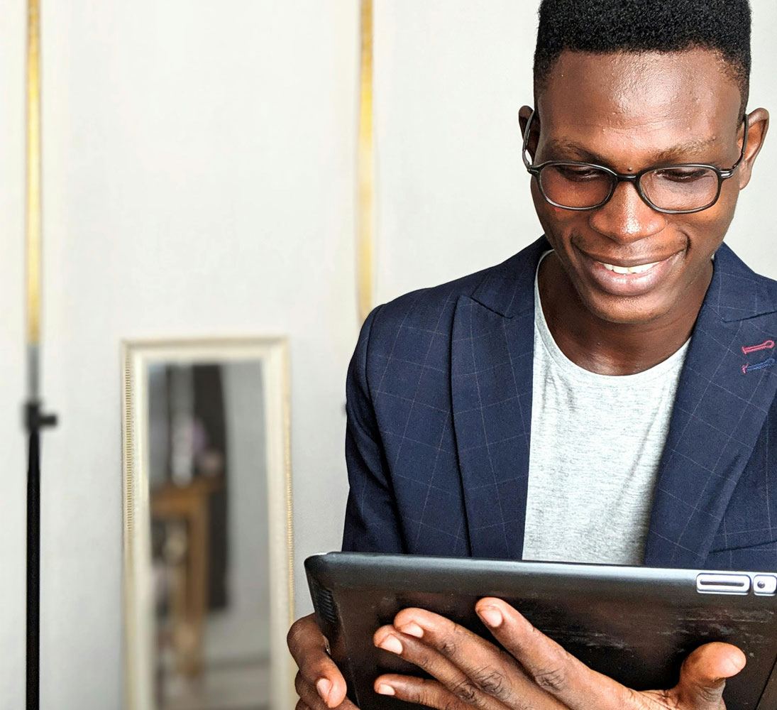 African American man on ipad smiling